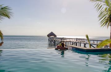 Woman in swimming pool looking out to the ocean from Dugong Beach Lodge