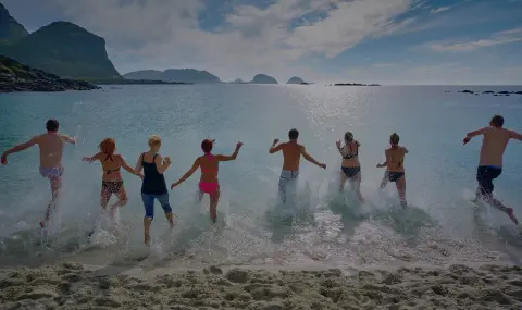 a group of people running into the ocean